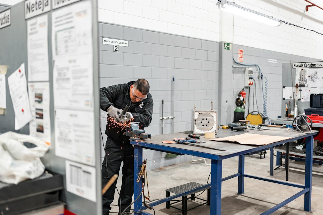 Technician using an angle grinder at a fabrication workbench; contextual image for welding procedure and craftsmanship story