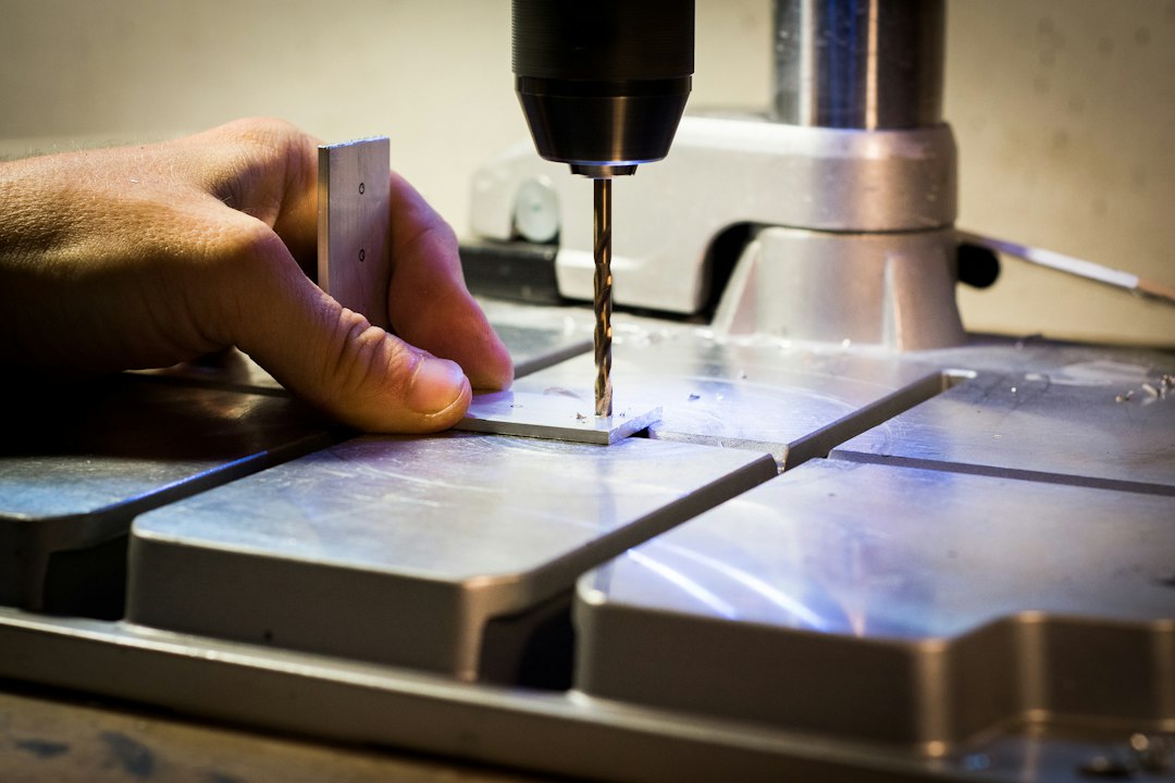 Operator using a drilling machine in a metalworking shop; contextual image, not the Hougen HMD904