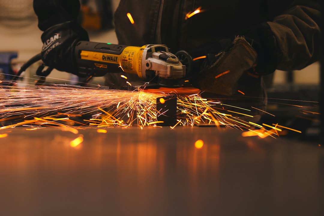 Metal-grinding work photographed by Heber Davis; contextual fabrication image, not a product photograph or demonstration of the DEWALT DWE402.