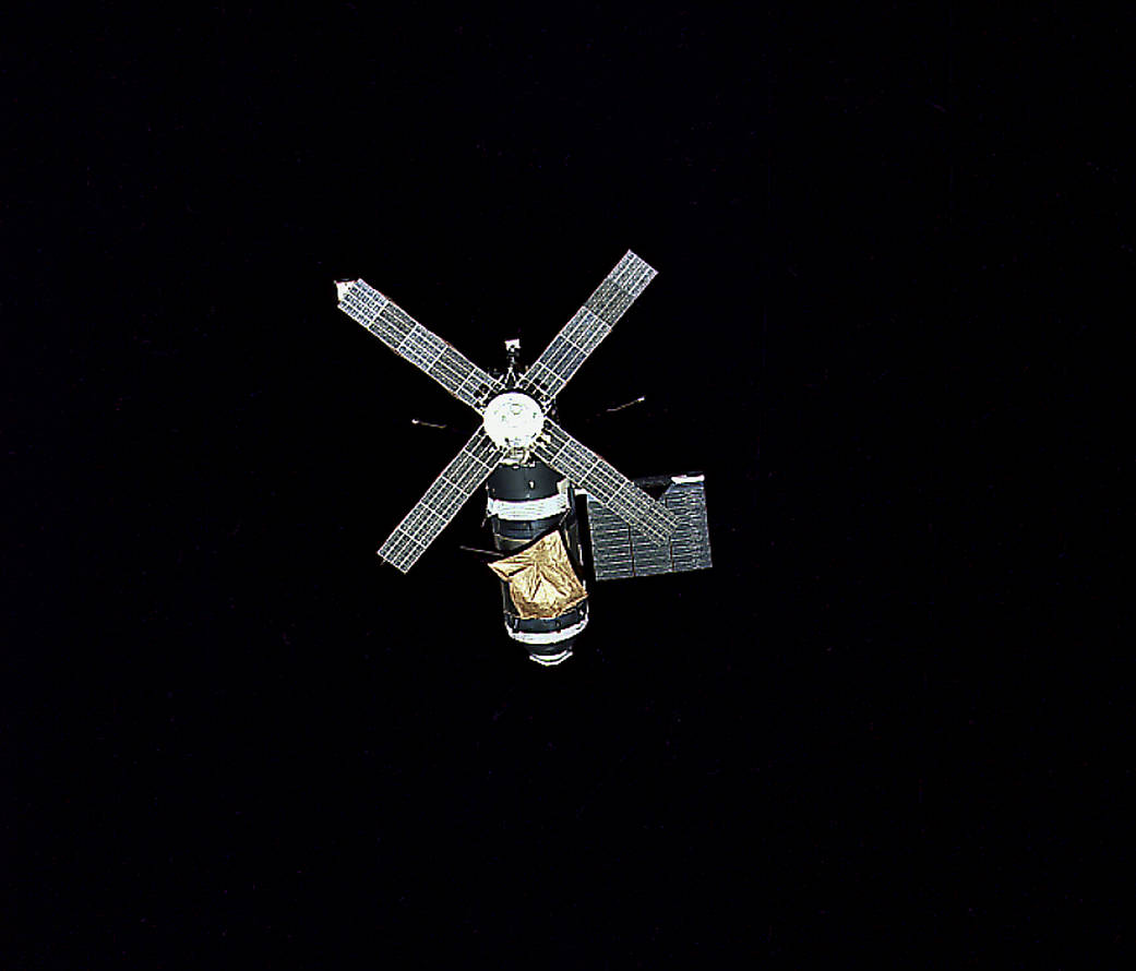 Skylab space station in orbit with its gold-colored sunshade and solar arrays; NASA/MSFC image.