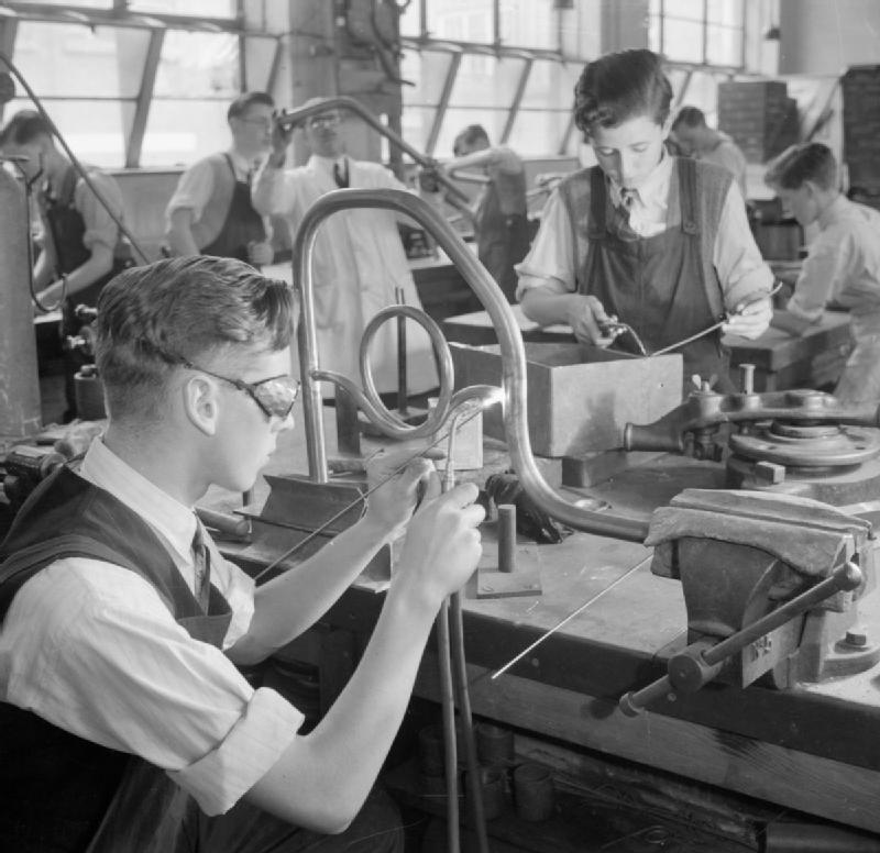 Archival black-and-white photograph of students and an instructor working with metaljoining tools at Tottenham Polytechnic in 1944; historical practices, not modern safety guidance.